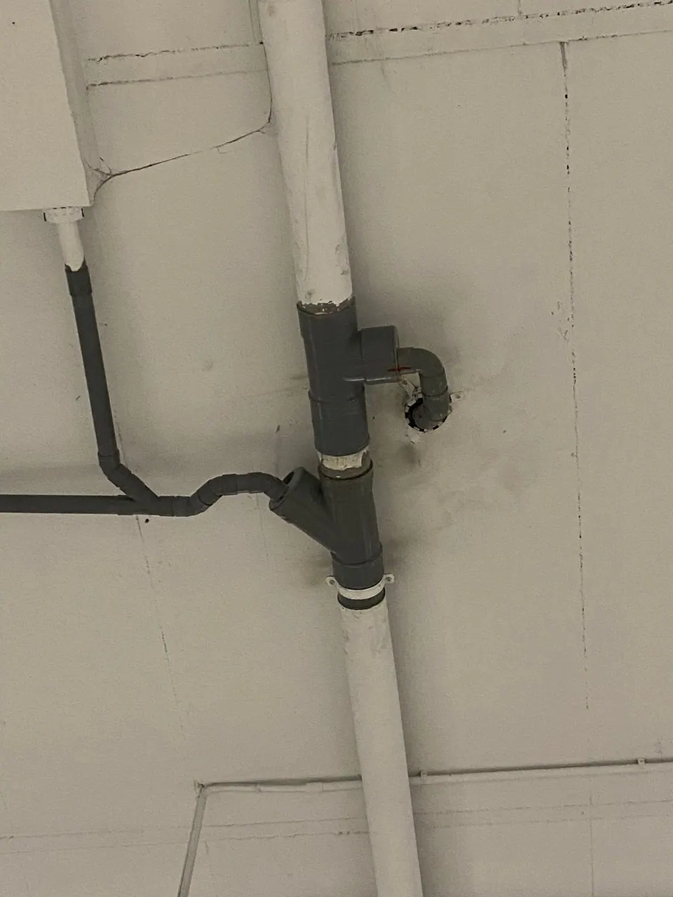 Conexión de desagüe y tubería vista en una pared