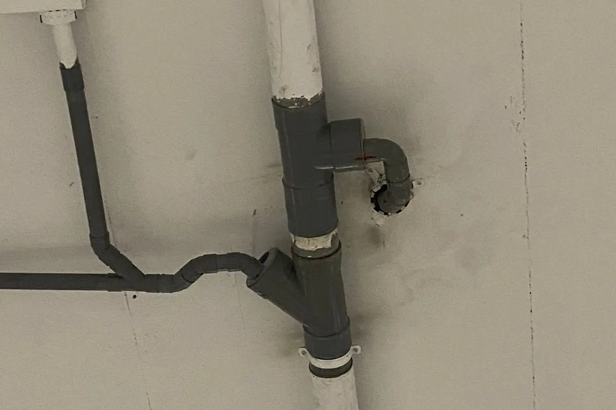 Conexión de desagüe y tubería vista en una pared