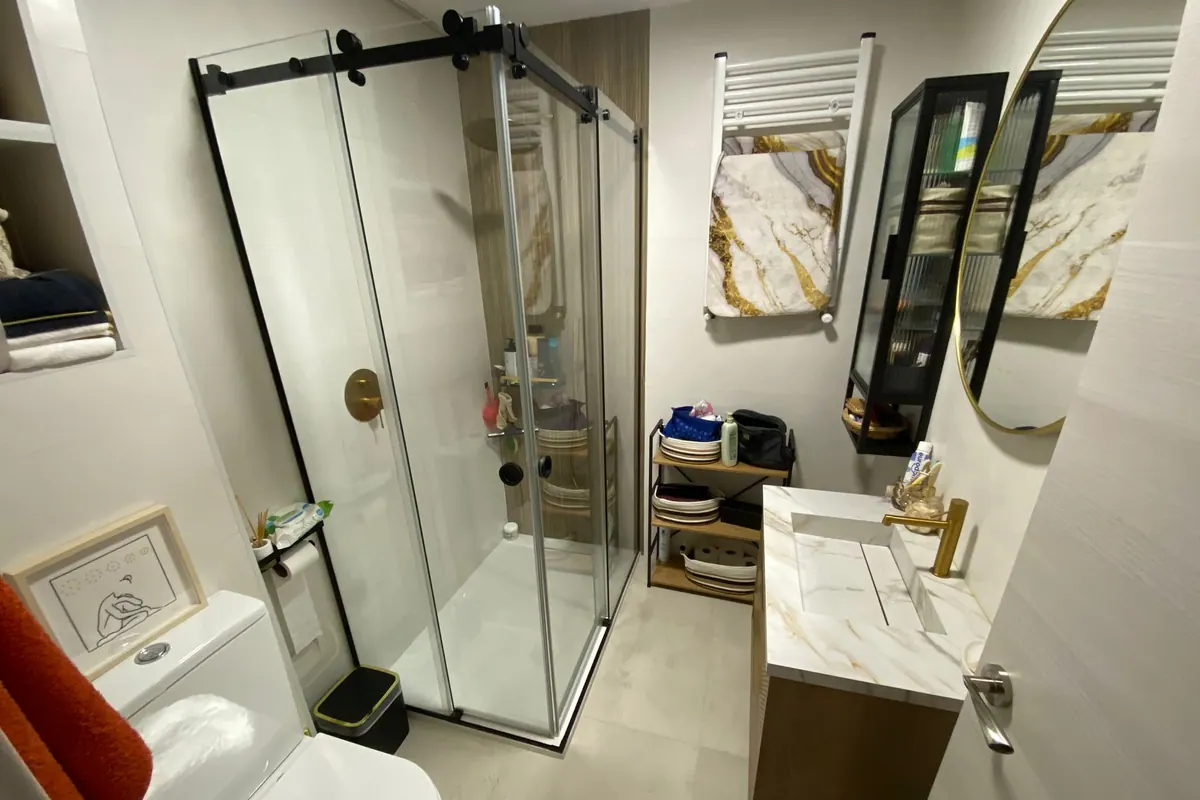 Mampara de ducha con perfiles negros instalada en un baño