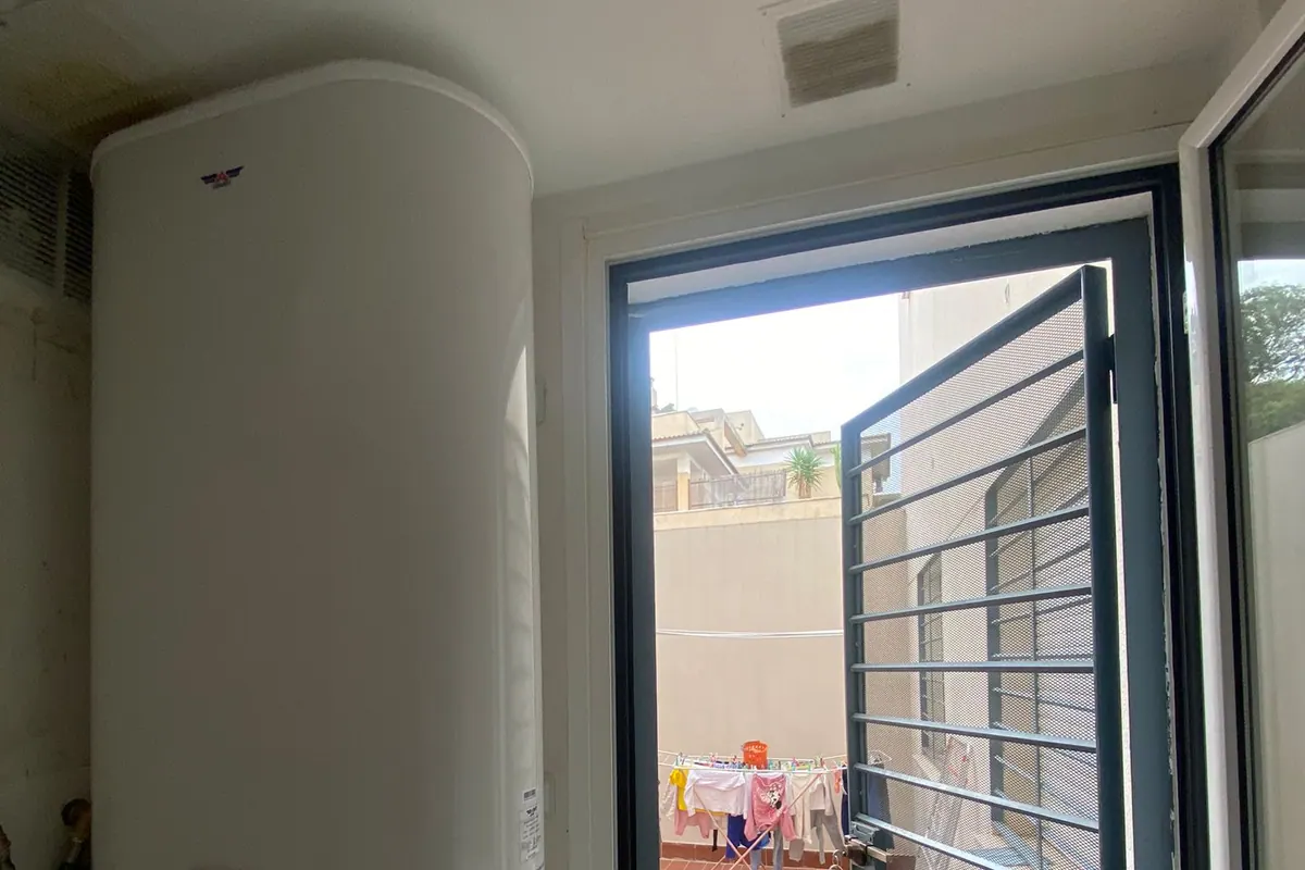 Termo eléctrico vertical instalado junto a una puerta