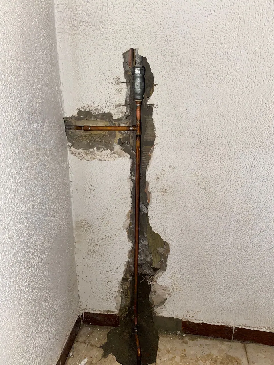 Tubería de agua visible en una pared abierta para su reparación