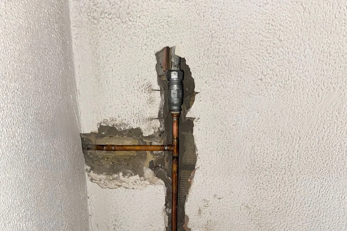 Tubería de agua visible en una pared abierta para su reparación